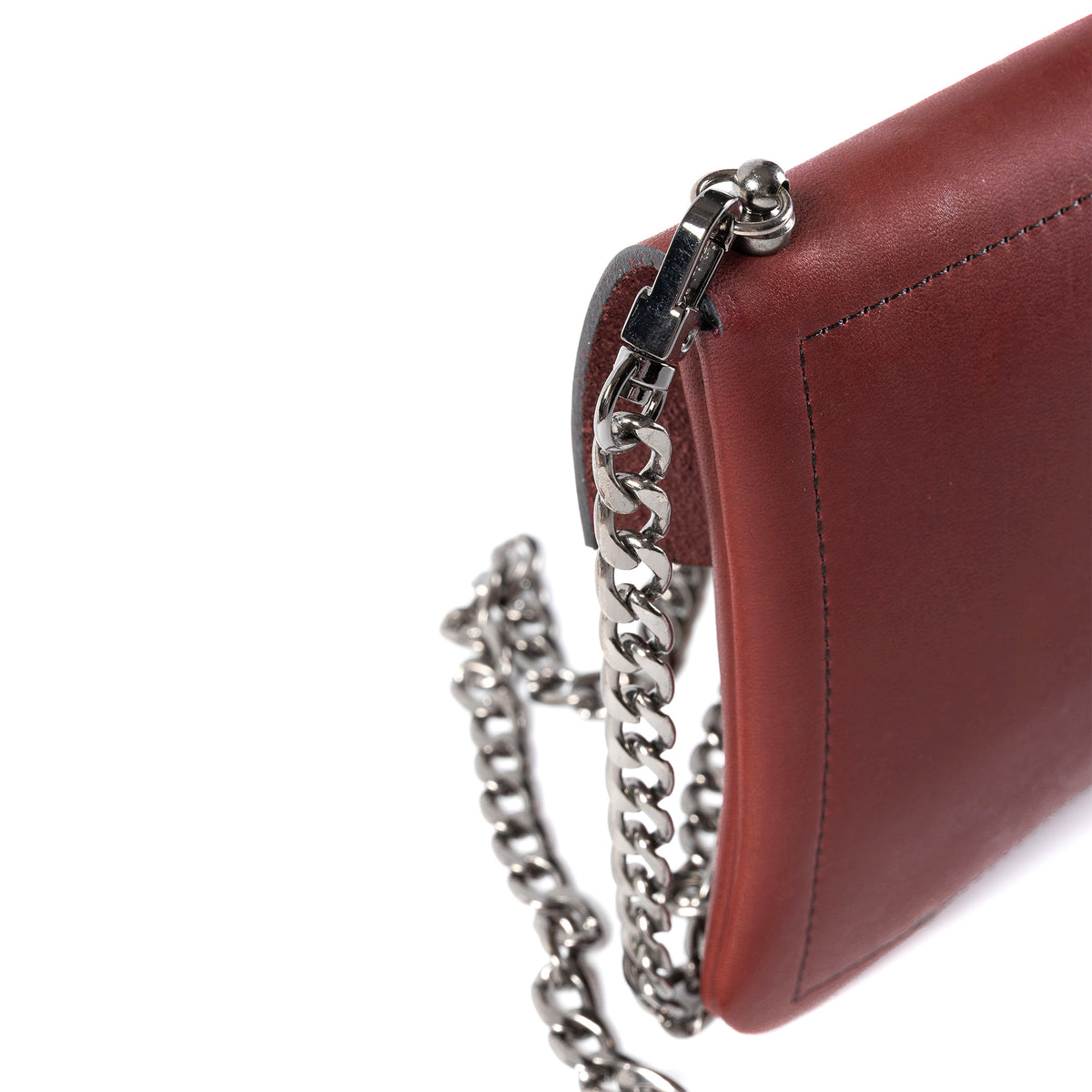 A close-up of a reddish-brown leather shoulder bag with a silver-tone chain strap and clasp, shown against a plain white background.