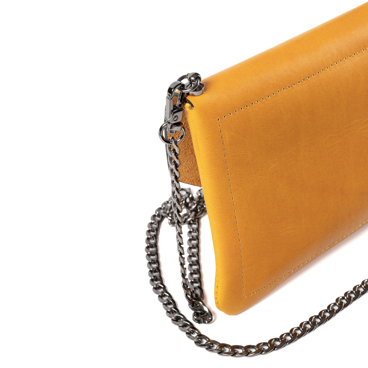Close-up of a mustard yellow leather clutch bag with a dark silver chain strap on a white background.