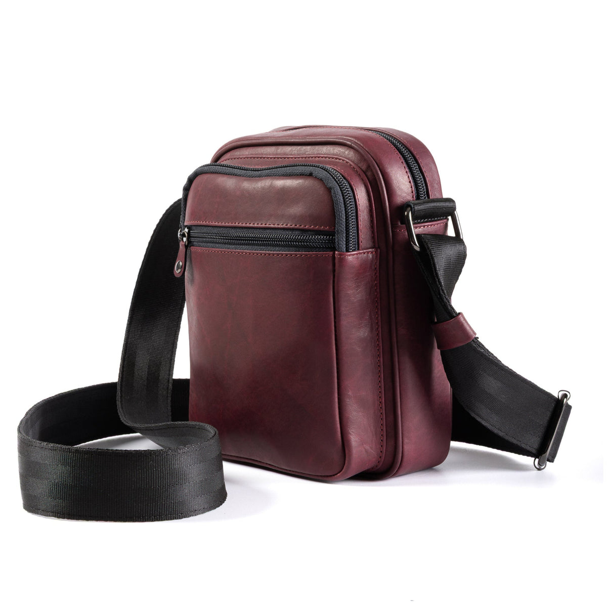 A burgundy leather crossbody bag with a black adjustable strap and black zipper trim, displayed on a clean white background.