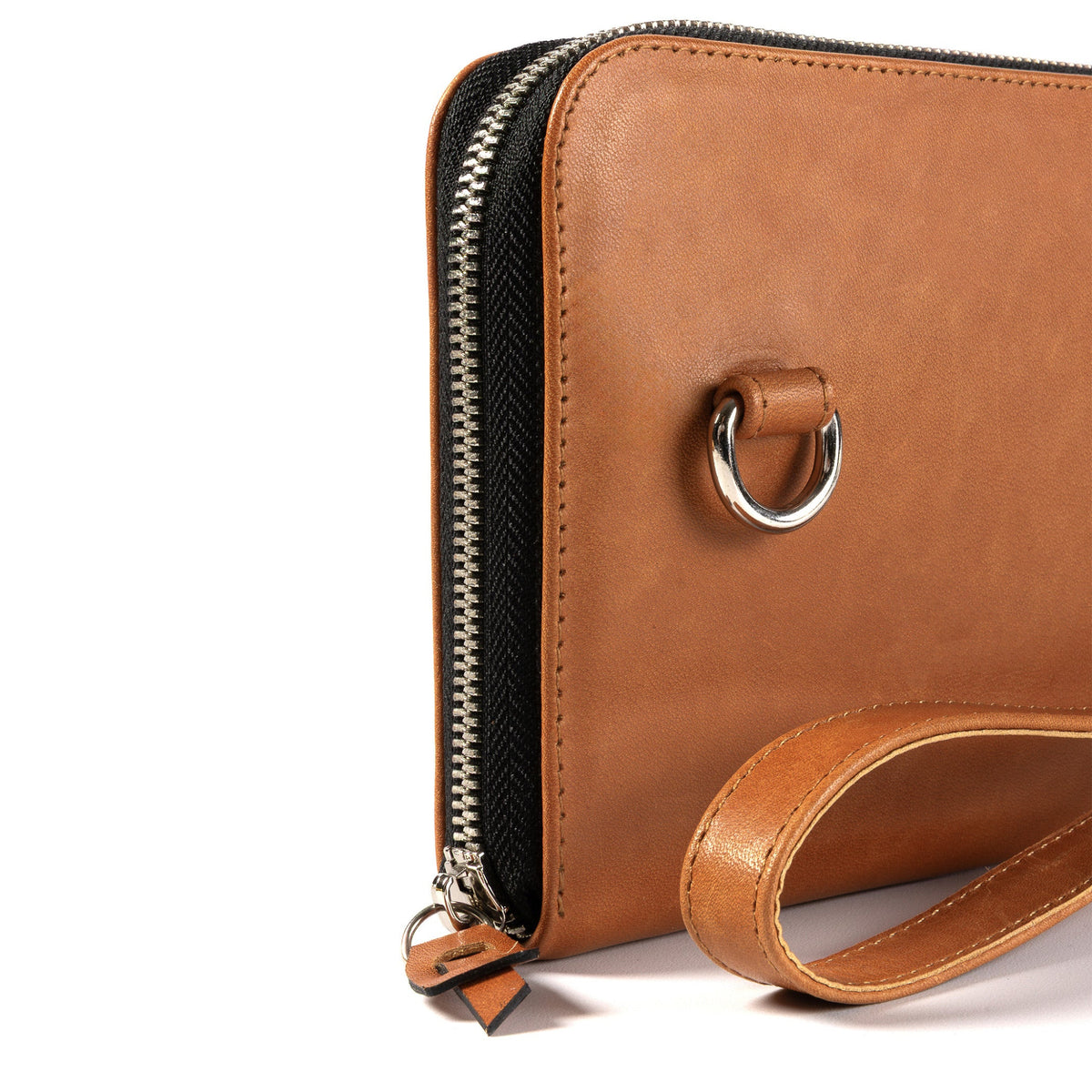 A close-up of a tan leather zip-around clutch or wallet with a black textured zipper track, silver metal hardware, and a matching leather wristlet strap on a white background.