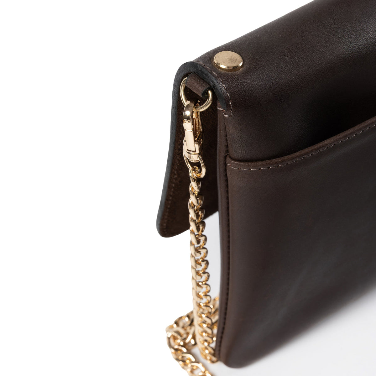 Close-up of a dark brown leather clutch bag showing a gold-tone metal snap button, zipper pull, and chain strap on a white background.